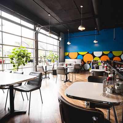 Interior, seating area with big windows on the left.