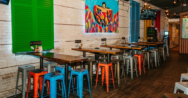 Interior space, seating area, high tables and stools lined up by the wall