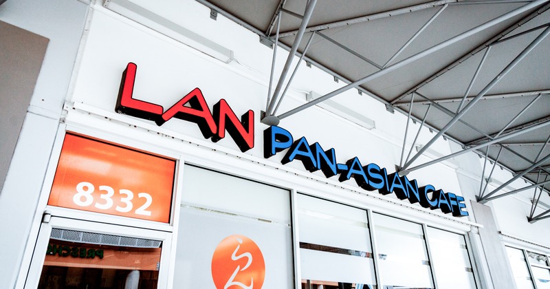 Exterior, low angle view to restaurant, entrance, sign above