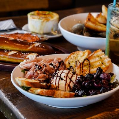 Burrata with toasted bread, alongsidde other dishes on the table.