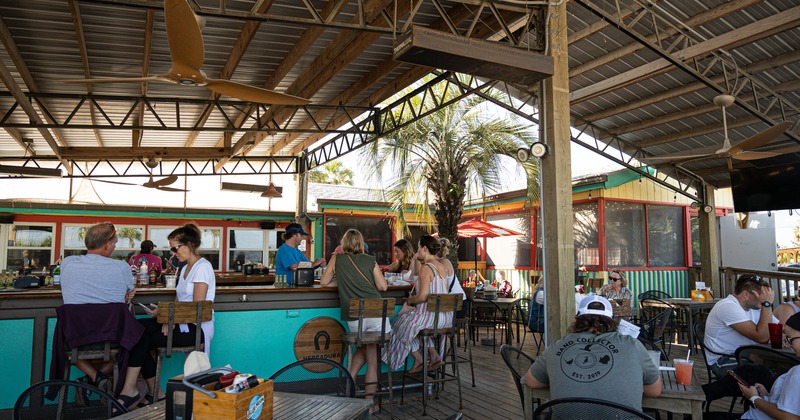 Exterior, covered seating area, counter, tables, chairs, people