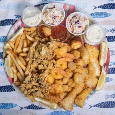 Fried seafood platter with fish, shrimp, clams, coleslaw, and tartar sauce.