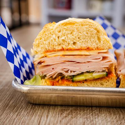 A close-up of a turkey sandwich layered with cheese, lettuce, and cucumber.