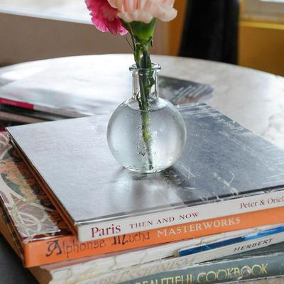 Interior detail, fresh flowers in a vase placed on books
