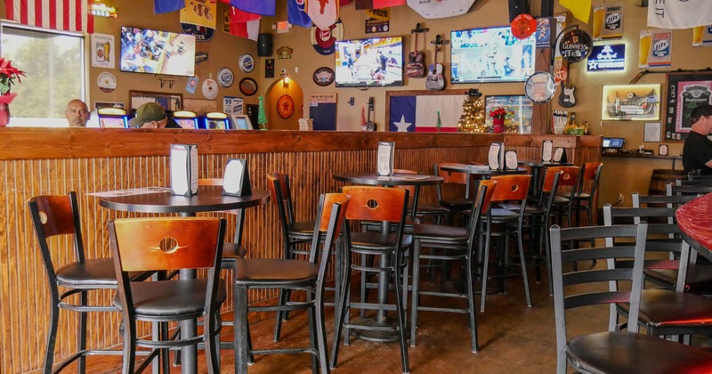 Interior of sports bar, seating area with high tables and stools