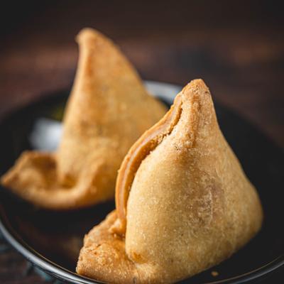A plate with two samosas, close up.