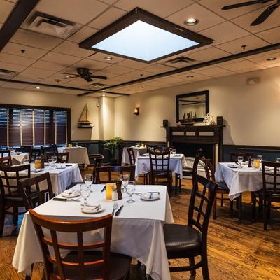 A room set for dining, featuring elegant table settings and soft lighting.