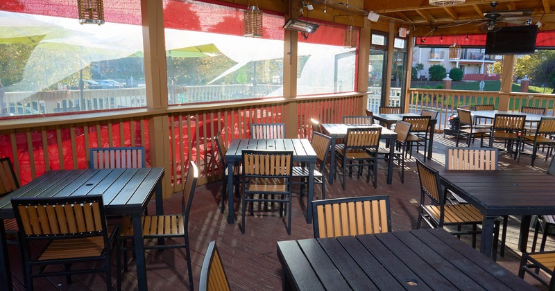 Exterior, patio, covered seating area, tables for four, wooden deck flooring