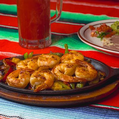 Shrimp fajitas served with a michelada.