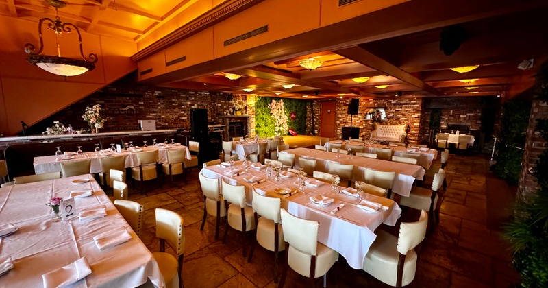 Interior, spacious dining area, tables with white tablecloths and place settings