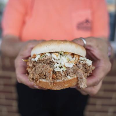 barbecue sandwich with coleslaw and hot sauce.