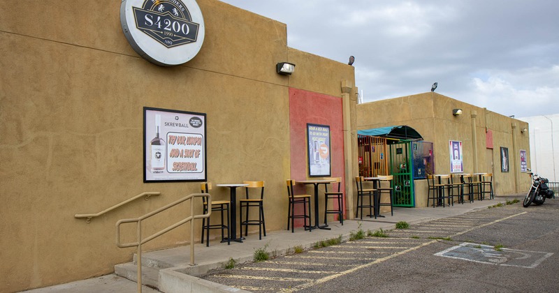 Exterior, bar tables for two and chairs in front of the entrance