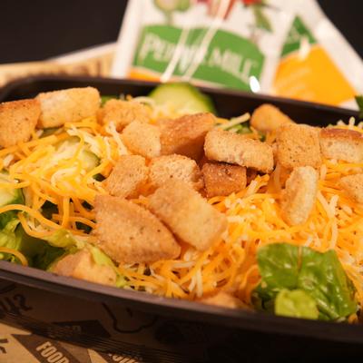 Salad topped with grated cheese and croutons.