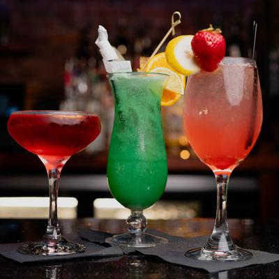 Assorted cocktails arranged on a bar counter.