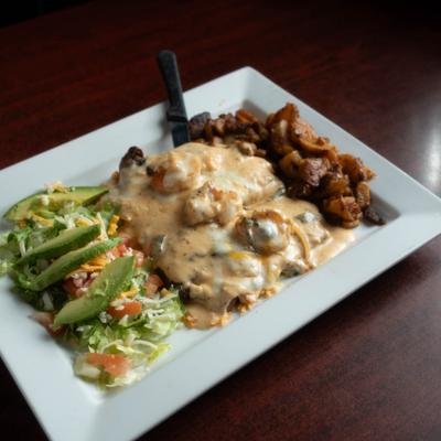 Grilled tilapia filet topped with poblano sauce served with garlic shrimp, potatoes and salad.