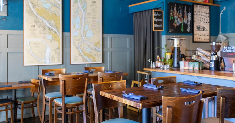 Interior, dining area, high seating tables with stools, bar on the right