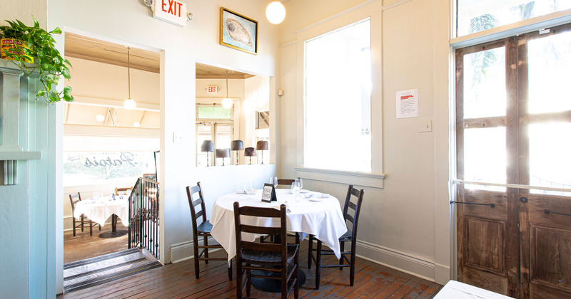 Interior - table with white tablecloth, brown wooden chairs around it