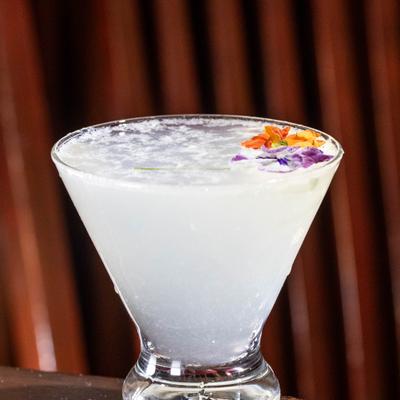 Pear Elderflower cocktail garnished with flowers.