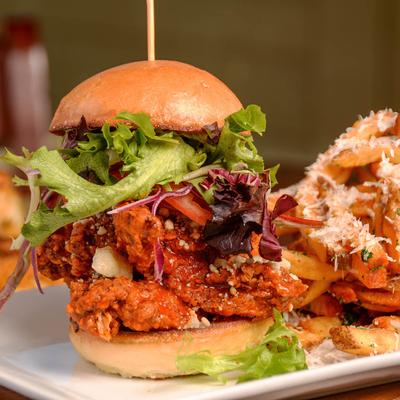 Fried chicken breast, buffalo sauce, blue cheese crumbles, lettuce, tomato and onion on a brioche bun