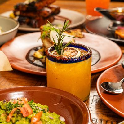 Margarita surrounded by various food plates.
