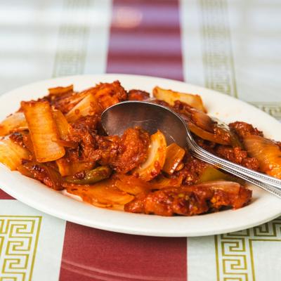 Chicken chilly fry with onions on a plate.
