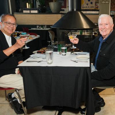 Two individuals enjoying a meal together at a restaurant table.