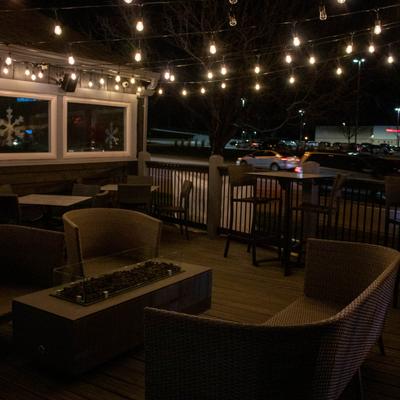Outdoor patio seating under string lights.