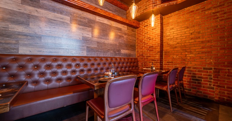 Cozy restaurant interior with brown leather seating and brick walls