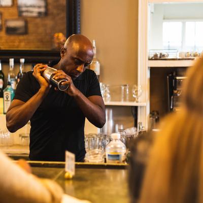 Person making cocktail at the bar.