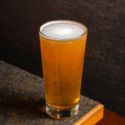 Glass of beer served on a dining table.