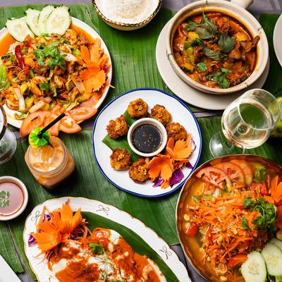 Miscellany of dishes and drinks spread on a table, top down view.