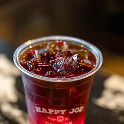 Cold brew coffee served in a clear plastic cup, close-up.