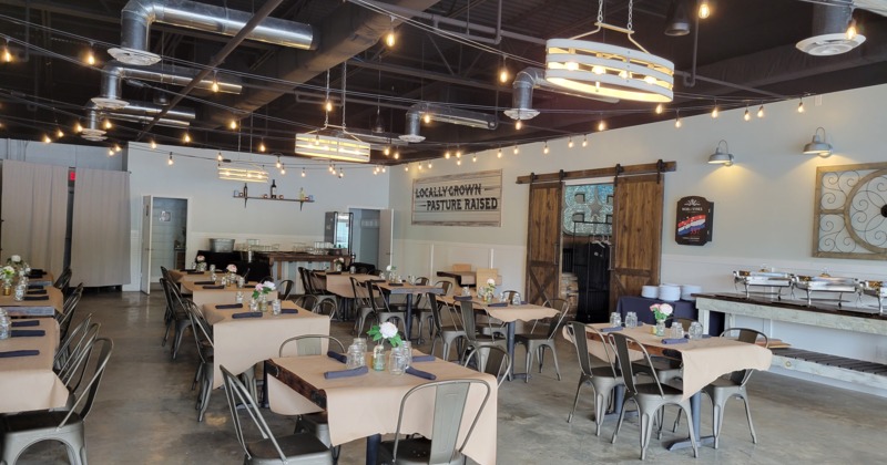 The bar, wall TVs, bar area with chairs and a long table