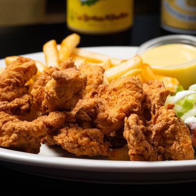 Crispy chicken pieces served with fries and dipping sauce.
