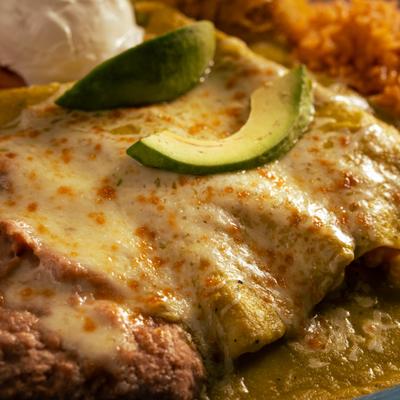 Shrimp Enchiladas topped with avocado slices, close-up.