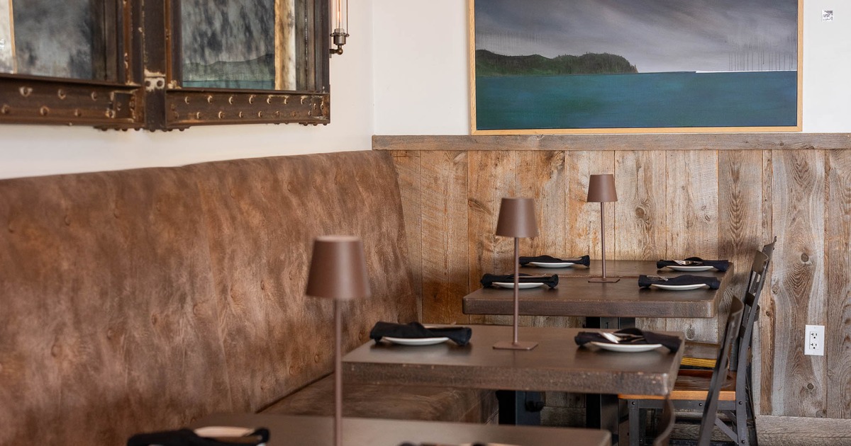 Cozy restaurant interior with leather banquettes and wooden tables