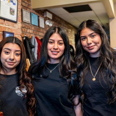 Three restaurant staff members posing together inside the restaurant.