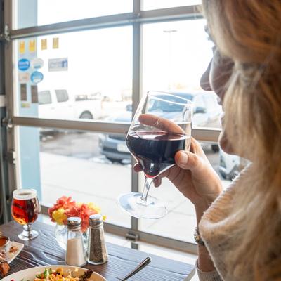 A customer enjoying a glass of red wine at a table.