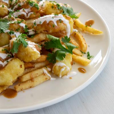 Loaded fries topped with fried shrimp, fresh herbs and a drizzle of white sauce.