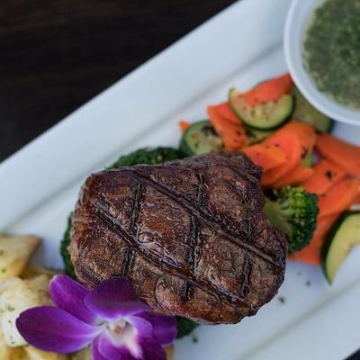 Plate with grilled filet mignon with vegetables and roasted potatoes.