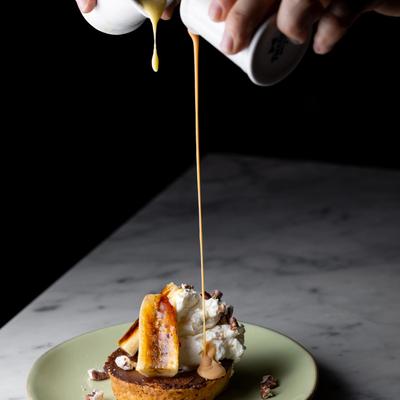 Melted cheese being poured onto dish