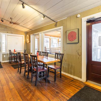 Interir with wood paneling on the walls and floors, tables and chairs.