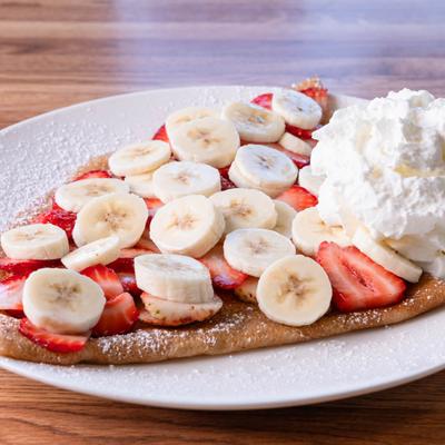 La Galaxy crepe with strawberries, bananas, and whipped cream.