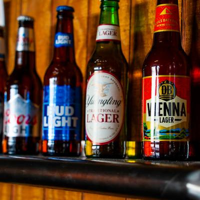 Assorted bottled beers on a bar shelf.