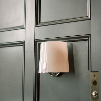 A lamp on a wooden wall panel.