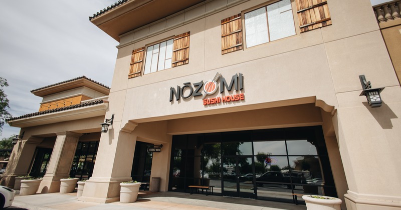 Corner view of the entrance, restaurant sign above the colonnade