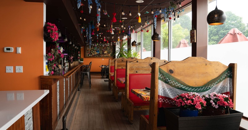 Interior of a colorful restaurant featuring red-upholstered booths