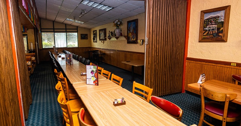 Restaurant dining area with long tables, wooden chairs