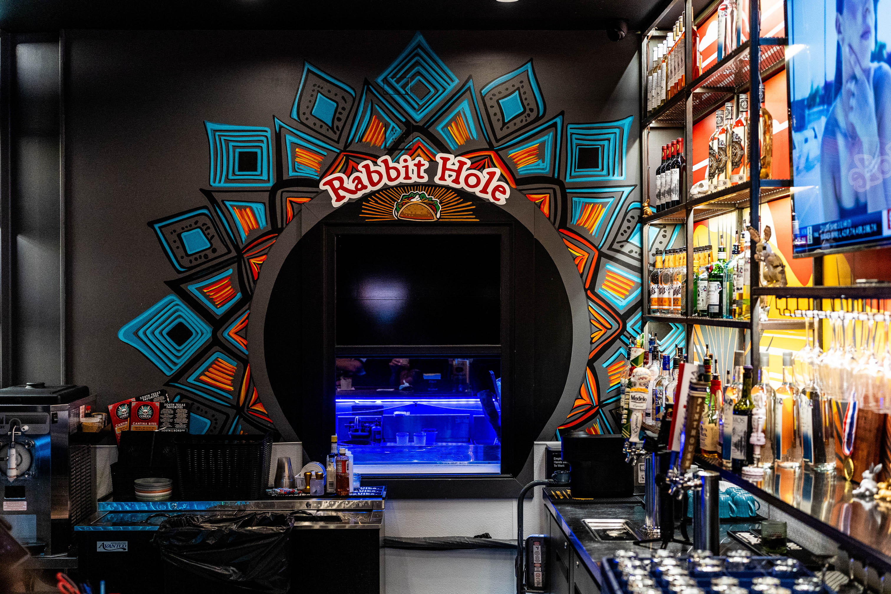 Interior featuring a circular portal window set against a dark wall adorned with mural