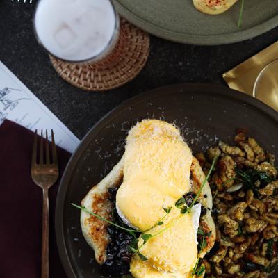 Eggs Benedict with mushrooms and a drink.